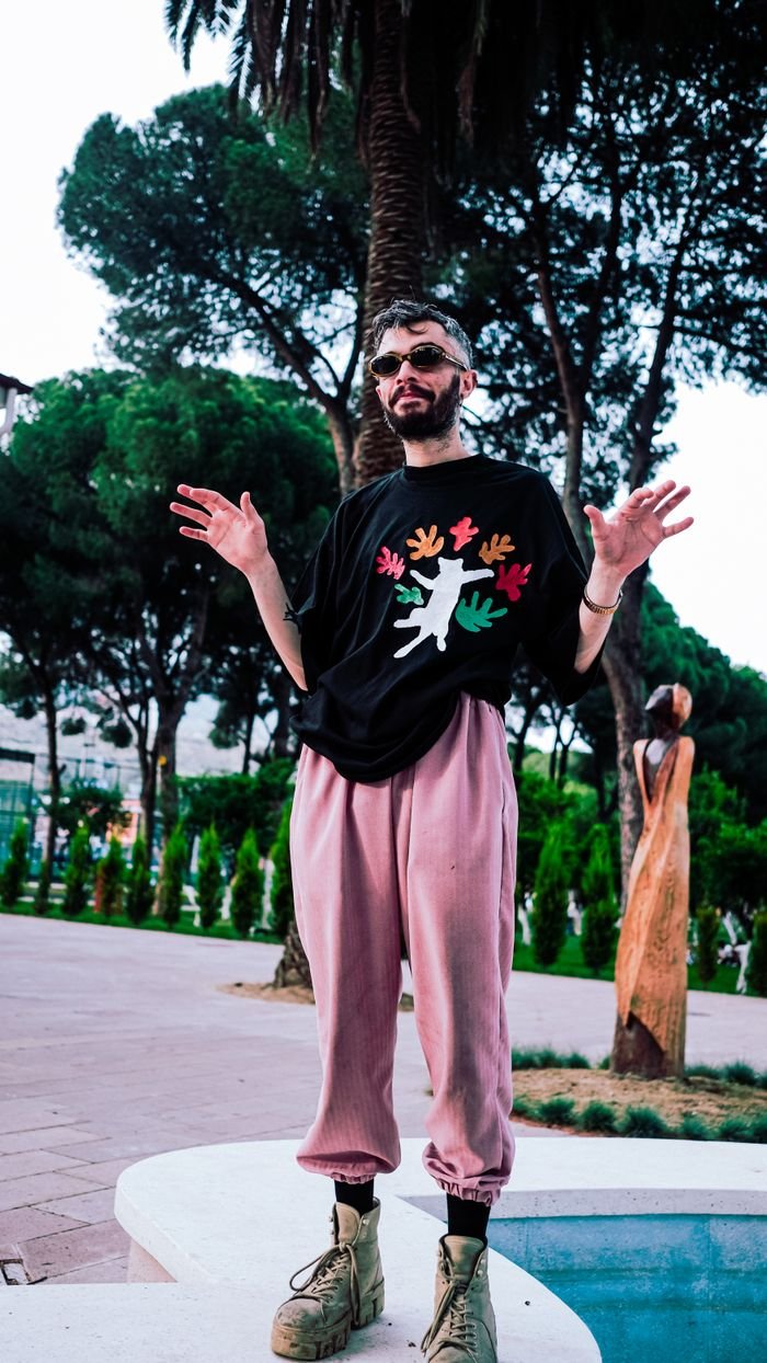 Fashionable man in sunglasses and vibrant shirt in urban park setting