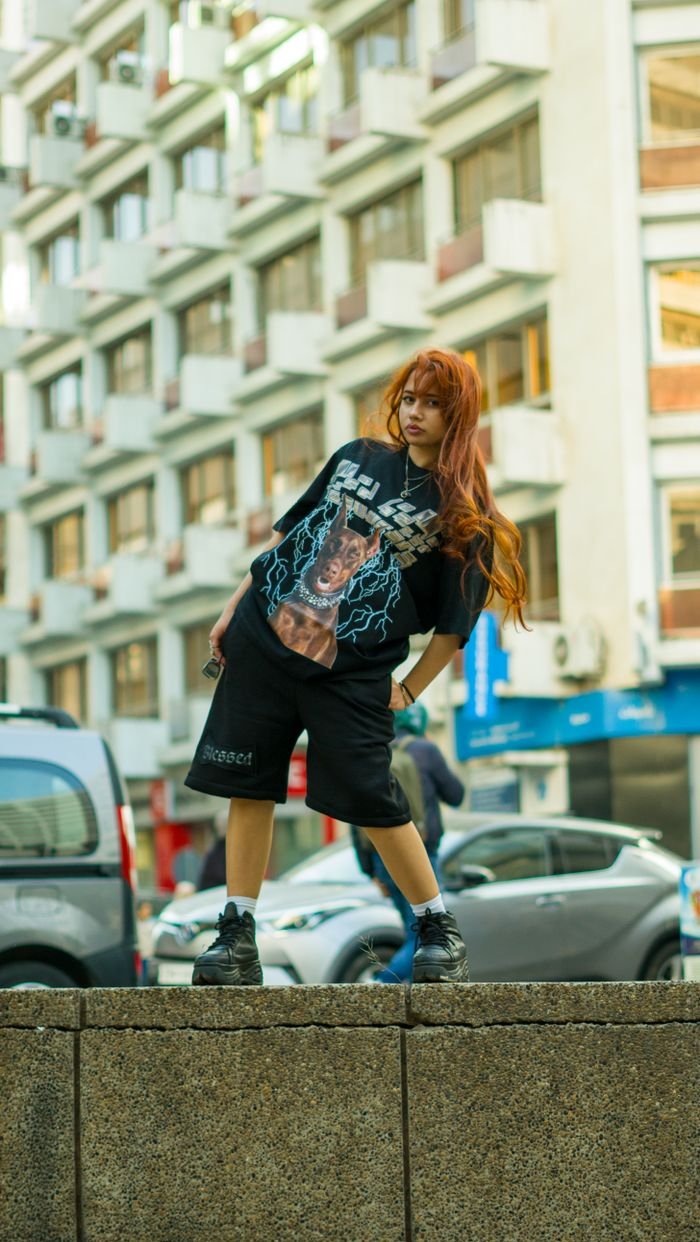 Fashionable young woman poses confidently in urban Maroc environment showcasing modern streetwear style.